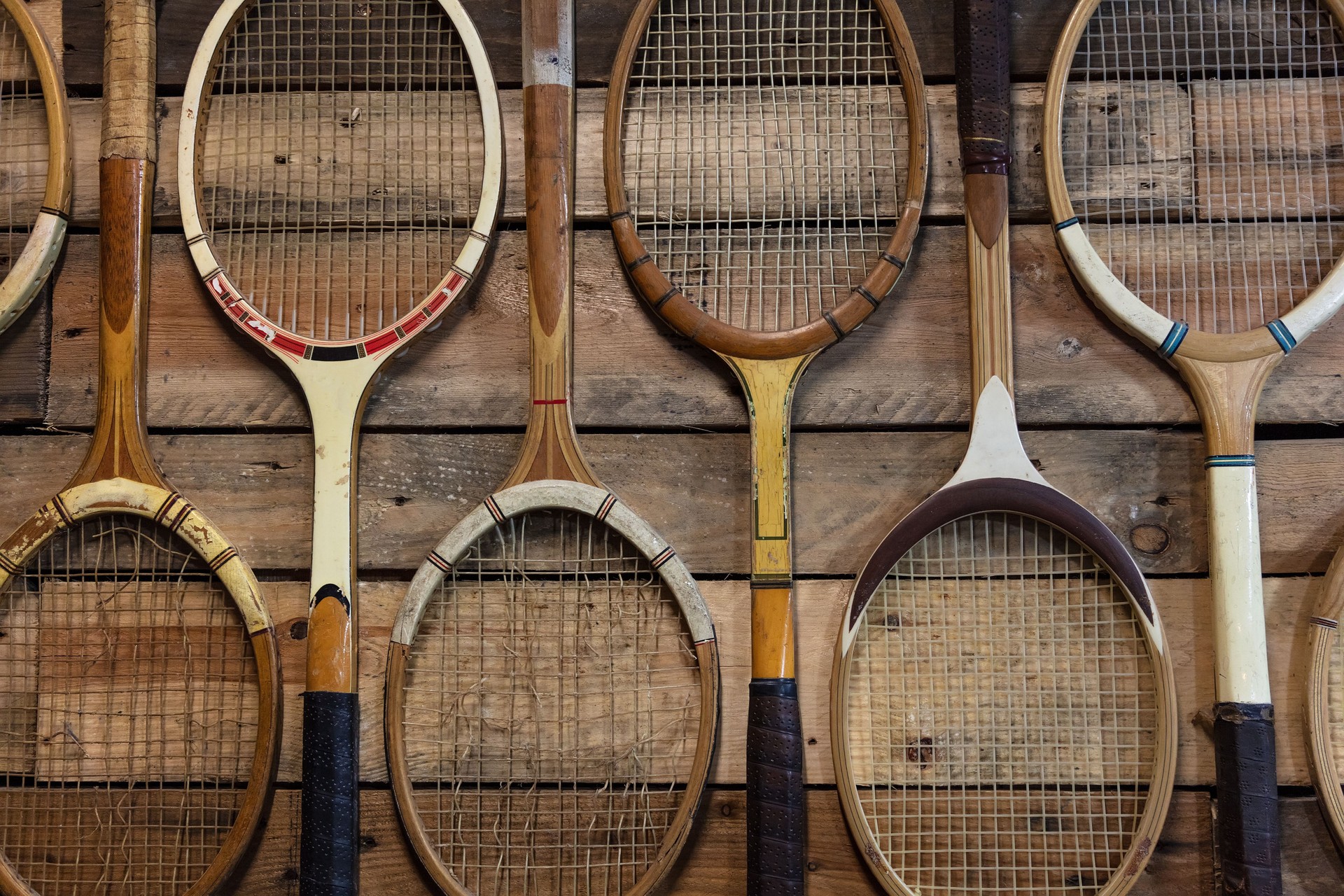 Vintage wooden tennis racquets arranged on wood planks